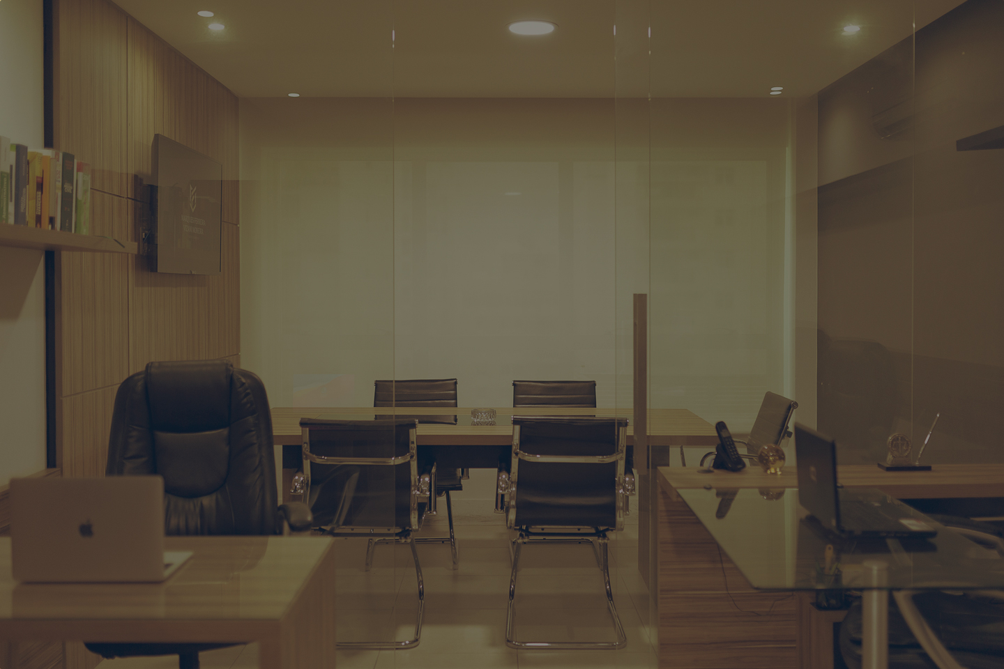 Sala de um escritório com cadeiras mesas e computadores